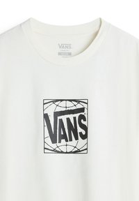 Camiseta de algodón blanca con un ajuste holgado, que presenta un destacado logo negro de "VANS" contornado en un cuadrado con un diseño gráfico texturizado.