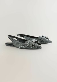 Juodos slingback balerinos su smailiu priekiu, dekoruoti baltais rhinestones ir dekoratyvine užriša priekyje. Lygus paviršius ir žemas kulnas.