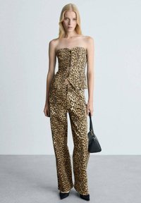 Top senza spalline in stampa leopardata abbinato a pantaloni a gamba larga. Realizzato in tessuto morbido, presenta un design strutturato e una chiusura frontale unica.