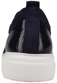 Vue arrière de sneaker marine avec un talon noir brillant, une tige en daim, une languette en tissu marine et une semelle épaisse et texturée blanche.