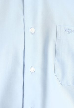 Camisa de algodón azul claro con un tejido texturizado, que presenta botones blancos y un bolsillo en el pecho con detalle del logo bordado.