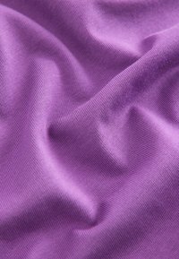Tejido morado con una fina textura acanalada, que muestra suaves y lisos pliegues y un ligero brillo, enfatizando su estructura flexible.