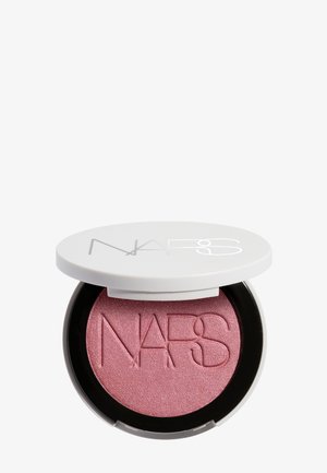 Boîte compacte ouverte d'un blush NARS rose scintillant avec un couvercle blanc affichant le nom de la marque dessus.