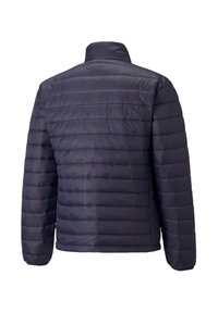 Jachetă căptușită de culoare bleumarin, cu un model de quilt vertical subțire, guler înalt și mansete elastice. Construită dintr-un material sintetic ușor și strălucitor.