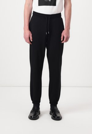 DUSPLITAN - Tracksuit bottoms - black