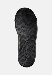 Svart gummiskosula med texturerade mönster och "CAMper"-varumärke. Storlek 38 angiven nära hälen för identifikation.