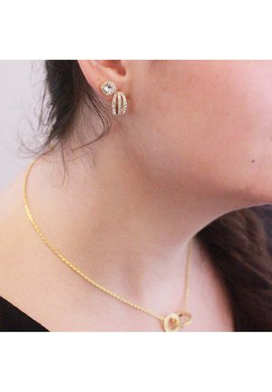 Vergoldete Ohrringe mit einem runden Stecker und einem Tropfen-Element, verziert mit klaren Strasssteinen. Goldkettchen mit rundem Anhänger.