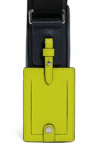 Borsa in tessuto nero con una brillante etichetta in pelle gialla attaccata. Presenta un bottone a scatto e una cucitura a contrasto lungo i bordi.