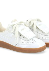 Baskets blanches en cuir avec motif perforé, fermeture à lacets et détail de franges. Semelle en caoutchouc avec accents marron pour traction et durabilité.