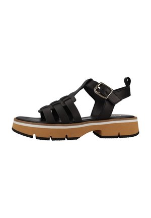 Sandalias negras de tiras con una suela gruesa color tostado, tiras texturizadas, hebilla ajustable y una pestaña en la parte trasera para ponerlas y quitarlas fácilmente.