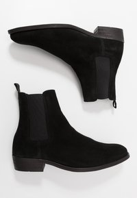 Svarta mocka Chelsea-boots med elastiska sidopaneler och dragrem; har en rund tå och låg klack.