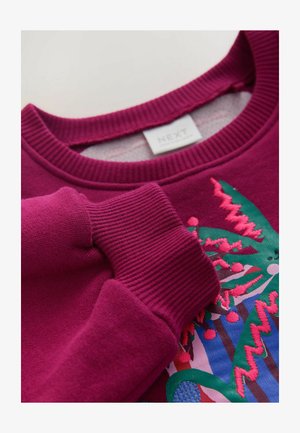 Fukszia pulóver bordázott mandzsettákkal és kerek nyakkivágással, élénk, hímzett növényi mintával az elején.