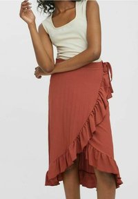 Rdzawoczerwona spódnica typu wrap z falbanami, wykonana z teksturowanej tkaniny. Została zaprojektowana z wiązaniem oraz asymetrycznym dołem.