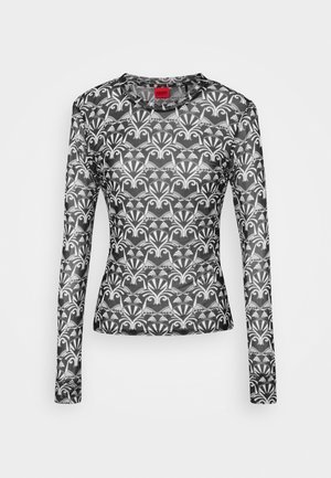 Haut ajusté à manches longues avec motif floral et géométrique symétrique noir et blanc et encolure ronde.