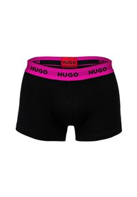 Schwarze Boxershorts mit einem leuchtend pinken Bund, der wiederholt schwarze "HUGO"-Logos zeigt, und einem roten Etikett mit "HUGO" in der Mitte hinten.