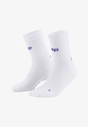White athletic socks with a ribbed texture, reinforced heel, and toe. Features purple branding on the sides. Mid-calf length design.