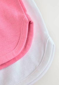 Tessuto di cotone rosa e bianco, con orli arrotondati. La trama è liscia con cuciture visibili lungo i bordi.