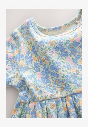 Vestido floral con textura acanalada, mangas cortas y cuello redondo. Flores azules, amarillas y rosas sobre un fondo claro.