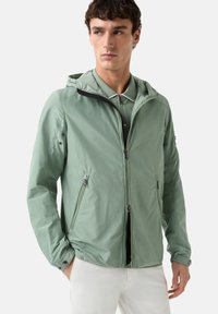 Light green lightweight jacket with a hood, zippered front, side pockets, and black accents, designed with a smooth, slightly glossy texture.