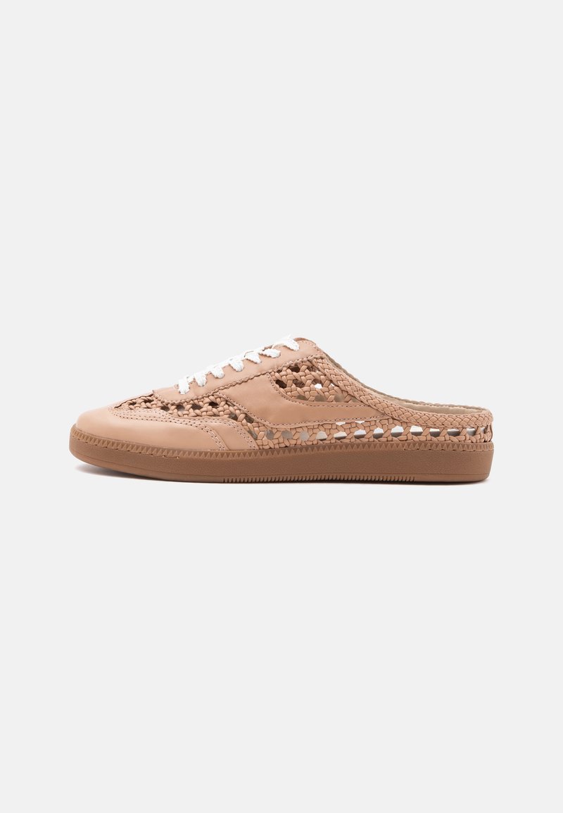 Μπεζ αθλητικό παπούτσι τύπου slip-on με λεπτομέρειες από πλεγμένο δέρμα, λευκά κορδόνια και επίπεδη καφέ λαστιχένια σόλα σε μονόχρωμο φόντο.
