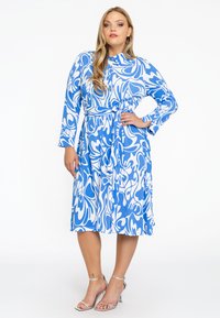 Blaue und weiße gemusterte Kleid mit langen Ärmeln, knöpfbarem Frontbereich und einer gebundenen Taillenpartie. Verfügt über einen glatten Stoff und einen knielangen Rock.