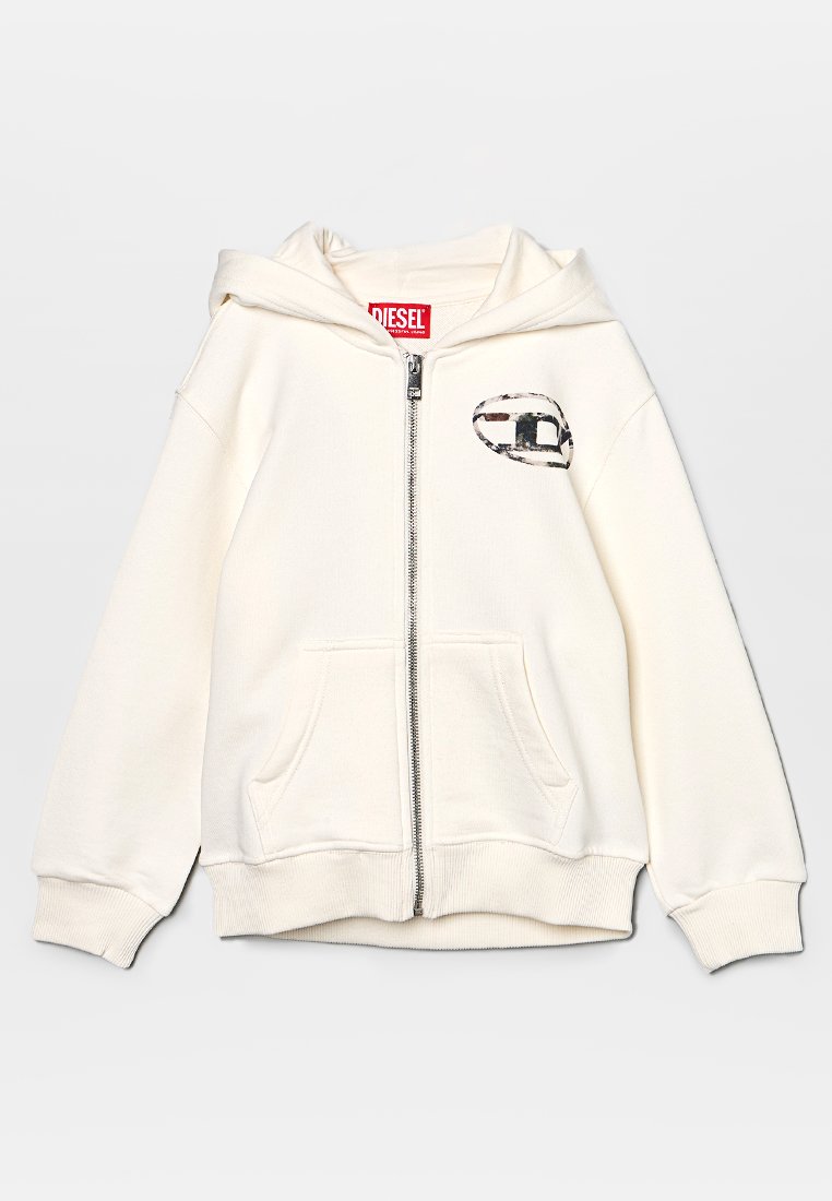 Felpa con zip di colore crema, dotata di tasche frontali, cappuccio e un piccolo logo a patch decorato sulla parte superiore sinistra del petto.