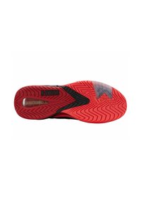 Semelle de chaussure de sport noire avec une semelle en caoutchouc rouge, présentant un motif en zigzag et un composant amortissant visible. Marque K-Swiss présente.