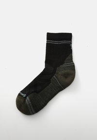 Black and green ankle sock with textured upper, reinforced toe and heel, and subtle gray stripes. Brand logo displayed on the side.