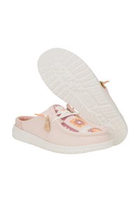 Zapatos de lona rosas tipo slip-on con acentos de tela de patrón floral, suela de goma blanca y detalles decorativos de borlas.