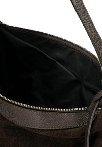 Tmavě hnědá kožená a semišová kabelka s černým textilním vnitřkem a částečně otevřeným stříbrným zipovým zapínáním.