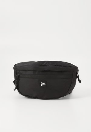 Black waist bag made of nylon; features a front zipper pocket, adjustable strap, and a logo patch. Rounded shape with a smooth texture.