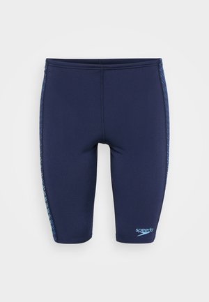 Jūras spēku peldētšorti ar ciešu piegriezumu, izgatavoti no gludas auduma. Iezīmēti ar zilām akcenta svītrām sānos un ar zīmola logotipu pie apakšmalas.