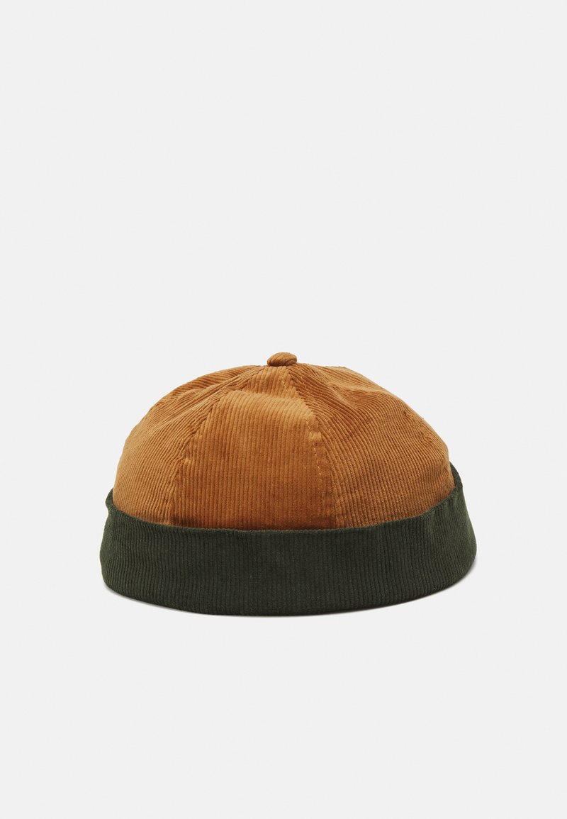 En cordfløyel caps med en brun krone og en grønn ribbet skjerm, med en rund form og en detalj med toppknapp.