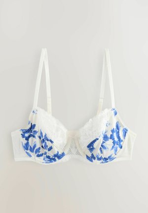 Witte beha met blauw bloemenpatroon, kantafwerking langs de cups, verstelbare bandjes en naadloze zijkanten voor een soepele pasvorm.