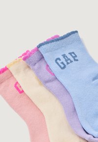 Conjunto de cuatro calcetines tobilleros en diversos colores pastel: rosa, amarillo, púrpura y azul. Cada uno tiene una textura acanalada y presenta un logotipo.