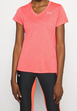 Person trägt ein korallfarbenes V-Ausschnitt-Sportshirt und schwarze Leggings mit korallfarbenen Seitenpaneelen, beide mit Under Armour Logos.