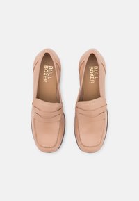 Nude leather loafers with a stitched accent and a smooth finish. Features a padded collar and textured rubber sole. Brand name visible inside.