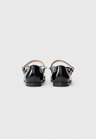 Chaussures en cuir verni noir avec une bride à la cheville et un petit talon, offrant une finition lisse et un design à bout rond.