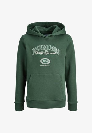 Sudadera verde con un bolsillo frontal y un logo blanco impreso, combinada con pantalones negros holgados y zapatillas blancas. Estilo casual, tejido suave.