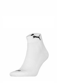 Vitt sportstrumpa med ribbad muddkant och svart Puma-logotyp nära toppen. Materialet verkar slätt med en sömlös tådesign.