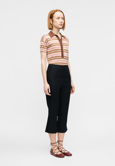 Πολύχρωμο ριγέ πόλο σε ροζ, καφέ και κρεμ, με καφέ γιακά και κλείσιμο με κουμπιά, σετ με μαύρο κα παρντινέ παντελόνι cropped και καφέ δερμάτινα παπούτσια με κορδόνια.