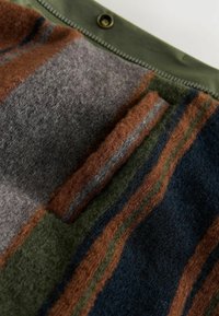 Wollstoff mit horizontalen Streifen in den Farben Braun, Grau, Grün und Blau, mit einer weichen Textur und einem Druckknopfverschluss am oberen Ende.