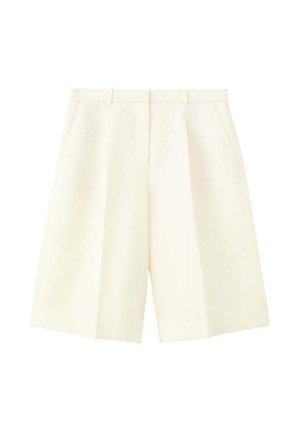 Pantalones cortos a medida de color crema con cintura alta, trabillas para el cinturón, pliegues delanteros y bolsillos laterales, exhibidos sobre un fondo blanco.