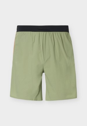 Lysegrønne shorts med sort elastisk linning, der viser bagsiden med enkel syning og uden synlige lommer.