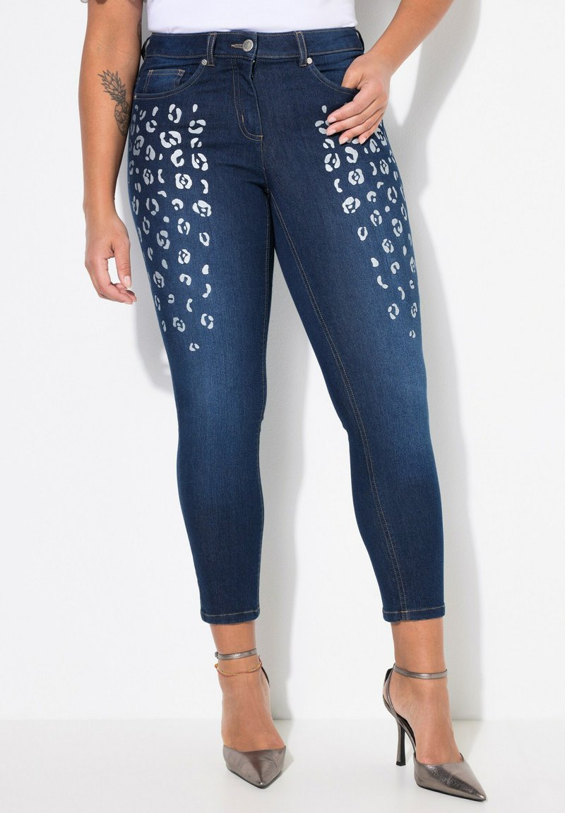 Ciemnoniebieskie skinny jeans z białymi akcentami w cętki na bokach, pięcioma kieszeniami i standardowym pasem.