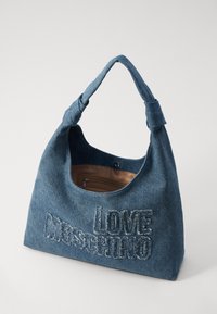 Denim skulderveske med en stor brodert "LOVE MOSCHINO" i kontrasterende tråd, med en myk tekstur og en rund, slitt form.