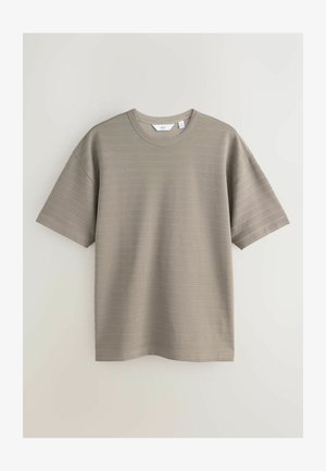 Beżowa prążkowana koszulka z krótkim rękawem i okrągłym dekoltem, rozmiar średni, prezentowana na białym tle.