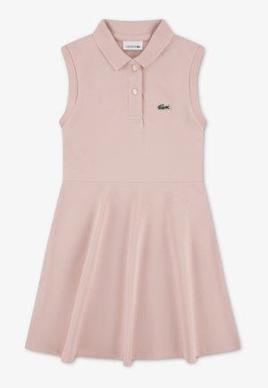 Robe polo en coton rose clair, design sans manches, jupe évasée, avec un petit logo Lacoste vert sur la poitrine et trois boutons au col.