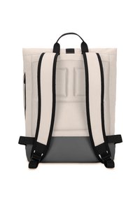 Beige tygryggsäck med svarta remmar, nätbakpanel och grå botten. Har ett handtag upptill och justerbara remmar.