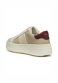 Baskets beiges avec une tige en cuir lisse, des accents en daim et un talon bordeaux. Elles présentent une épaisse semelle en caoutchouc blanc et un laçage simple.